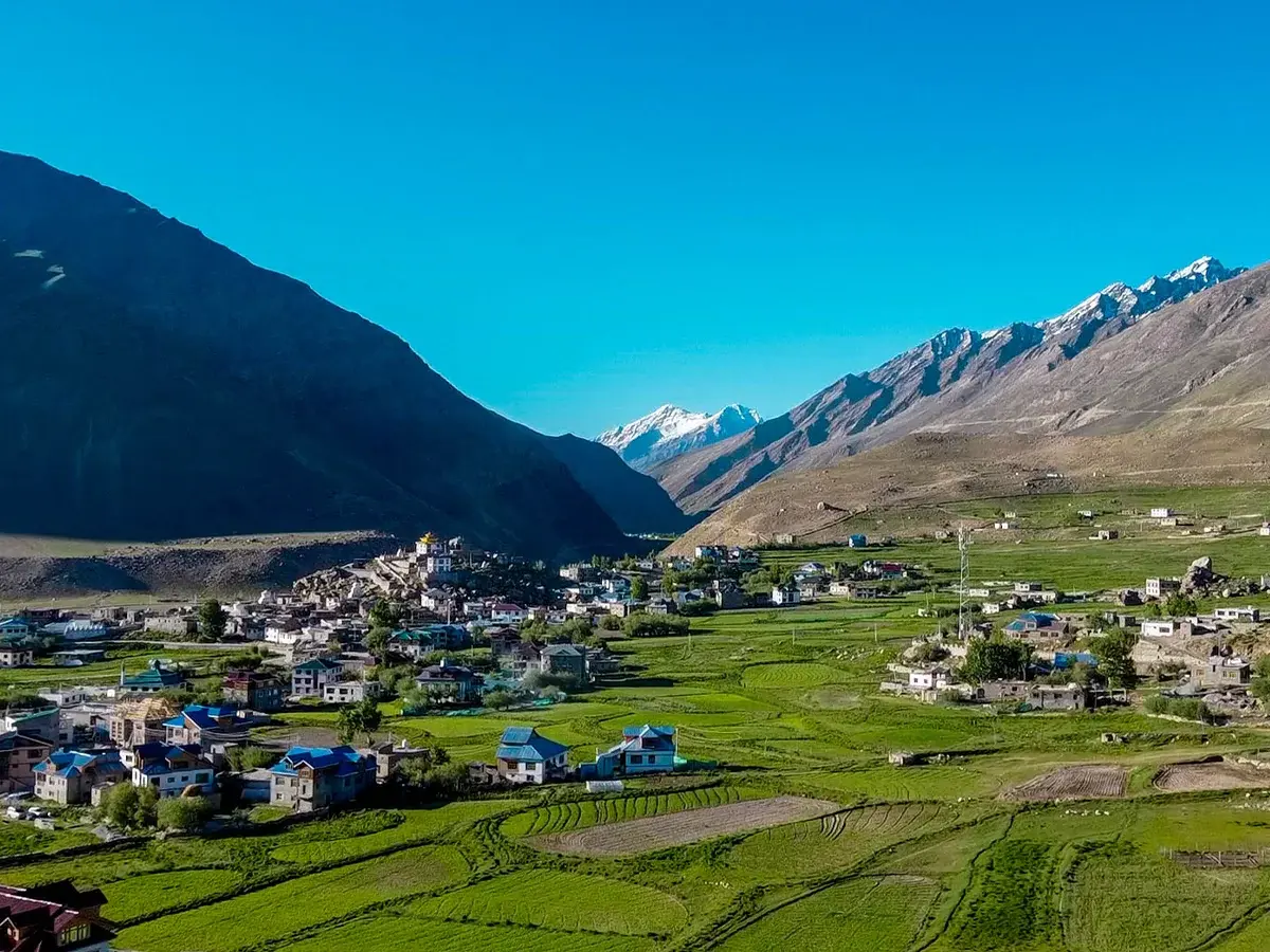 A wide-angle shot of Padum Zanskar Valley with mountains, monastery, and village houses